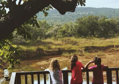 kids-standing-on-a-deck-looking-over-a-river